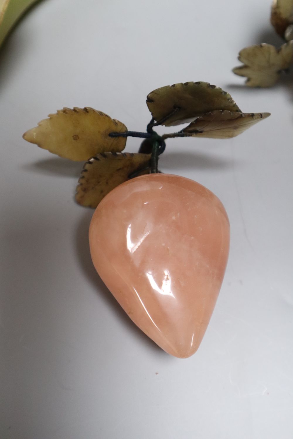 A Chinese soapstone lotus dish containing hardstone models of fruit and a hardstone model of flowers